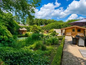 a backyard with a garden and a log cabin at Paping Hotel & Spa - Rest Vonck by Flow in Ommen
