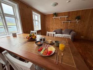 a wooden table with fruit on it in a living room at Cozy Home with Breathtaking Mountains and Sea Views in Flateyri