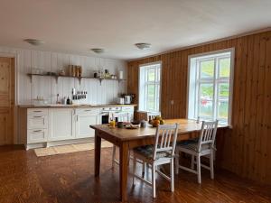 a kitchen with a wooden table and white cabinets at Cozy Home with Breathtaking Mountains and Sea Views in Flateyri +7 photos