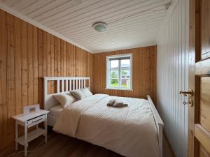 a bedroom with a white bed and a window at Cozy Home with Breathtaking Mountains and Sea Views in Flateyri