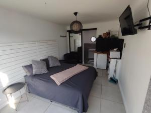 a bedroom with a bed and a chair and a television at 284 on circular 3 in Sunridge Park