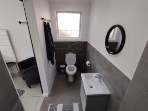 a bathroom with a toilet and a sink and a mirror at 284 on circular 3 in Sunridge Park