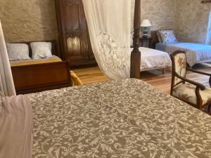 a bedroom with two beds and a bed with a blanket at Gîte de la Plonde in Labessière-Candeil