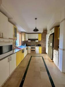 a kitchen with yellow and white cabinets and appliances at Villa Omi Zina in Nabeul