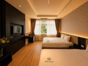 a hotel room with two beds and a television at D'la Lento Hotel in Hanoi +17 photos