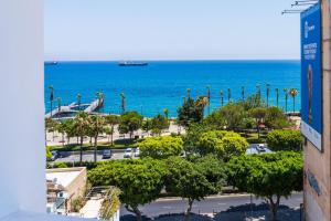 a view of the ocean and a parking lot with palm trees at Luxury 2BR Limassol Marina Views in Limassol
