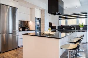 a kitchen with white cabinets and a stainless steel refrigerator at Luxury 2BR Limassol Marina Views in Limassol