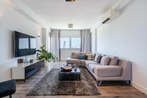 a living room with a couch and a tv at Luxury 2BR Limassol Marina Views in Limassol