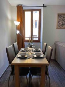 a dining room with a table with chairs and a couch at Appartement Moutiers Centre in Moutiers +10 photos