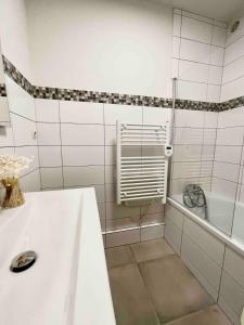 a white bathroom with a sink and a bath tub at Appartement Moutiers Centre in Moutiers
