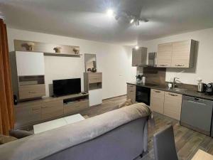 a living room with a couch and a kitchen at Appartement Moutiers Centre in Moutiers