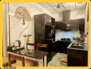 a kitchen with a tree mural on the wall at UDUPI HOMESTAY CHALET LA BONNE Vie in Udupi