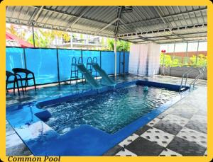 a swimming pool with a slide in the water at UDUPI HOMESTAY CHALET LA BONNE Vie in Udupi