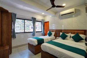 a bedroom with two beds and a window at Hotel Benz Inn in Mumbai