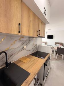 a kitchen with wooden cabinets and a counter top at Vila Šarić in Doglodi