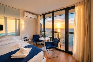 a bedroom with a bed and a view of the ocean at Orbi City Sea View Balcony ApartHotel in Batumi +74 photos
