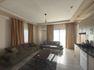 a living room with a couch and a table at Han Suite Ev-Otel Mersin in Kaleköy