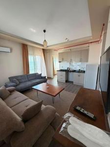 a living room with a couch and a table at Han Suite Ev-Otel Mersin in Kaleköy