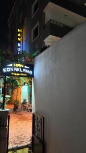a sign on the side of a building at night at Han Suite Ev-Otel Mersin in Kaleköy +3 photos
