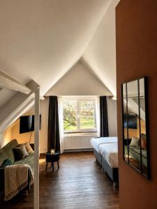 a bedroom with a bed and a mirror and a window at Paping Hotel & Spa - Rest Vonck by Flow in Ommen
