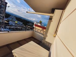 a balcony with a bed and a view of a street at Han Suite Ev-Otel Mersin in Kaleköy
