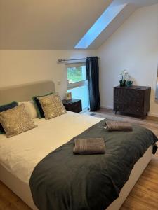 a bedroom with a large bed with two pillows at Chameleon House in Dornoch