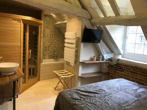 een slaapkamer met een bed, een wastafel en een bad bij L'envie d'ailleurs in Honfleur