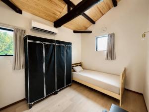 a bedroom with a bed and a black closet at 日和のすみか in Ichihara