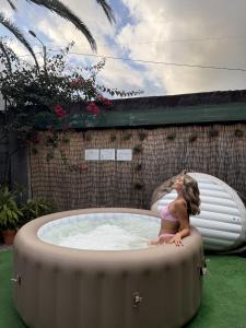a little girl is sitting in a hot tub at Gardens Guest House-Hostel in São Vicente +65 photos