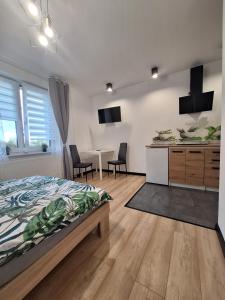 ein Schlafzimmer mit einem Bett und eine Küche mit einem Tisch in der Unterkunft Czarwoli in Wola Bokrzycka