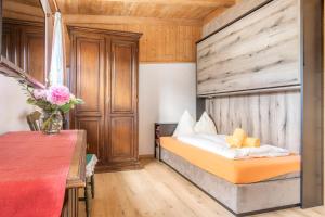 a bedroom with a bed and a wooden wall at Ferienhof Millinghof in Leogang +54 photos