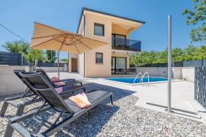 a patio with a chair and an umbrella next to a swimming pool at Villa LeSt in Gabonjin