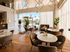 a room with tables and chairs and a couch at Saray Deluxe Hotel Apartments in Abu Dhabi