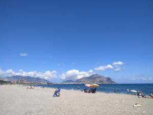 a group of people sitting on a beach at Catalano Suite Marina - Vista Mare in Palermo