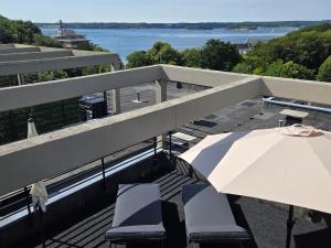 a balcony with a table and chairs and an umbrella at Förde Loge - Traumblick & Spa in Glücksburg