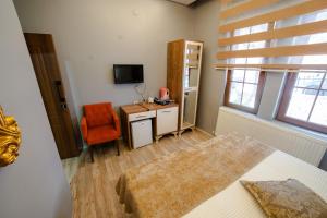 a bedroom with a bed and a desk and a television at Şehrizade Konakları in Amasya