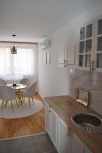 a kitchen with a sink and a table with chairs at Elite Suites - Vogošća in Vogošća +19 photos