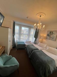a bedroom with two beds and a chandelier at A & B Guest House Cambridge in Cambridge