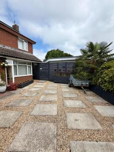 a driveway with a house and a building with a garage at Home Away From Home in Blean