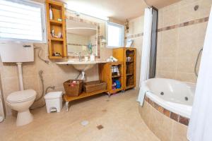 a bathroom with a toilet and a sink and a tub at נוף ארץ הגליל - צימרים מהממים במצפה נטופה in Mitspe Netofa +24 photos