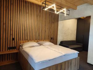 a bedroom with a large bed and a chair at Hotel Kras in Jedovnice
