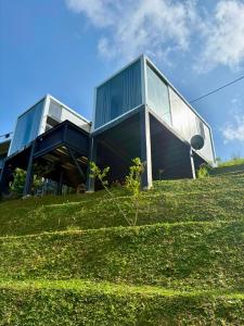 a house on top of a grassy hill at RuKu Villa Pussellawa in Pussellawa