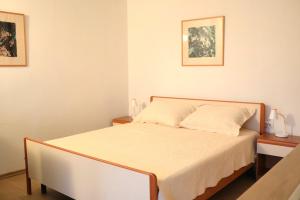 a bed in a bedroom with two nightstands and two pictures at Campanella Old Town by Mrav in Sukošan