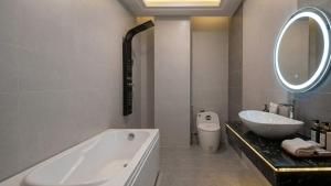a bathroom with a tub and a sink and a mirror at Mai Song Linh in Phan Rang–Tháp Chàm