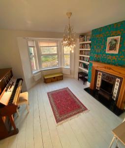 a living room with a piano and a fireplace at Strand Retreat in Tintagel
