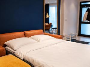 an orange couch in a room with a bed at Luxury Apartment Königsallee Old Town Rhine Promenade Messe in Düsseldorf +20 photos