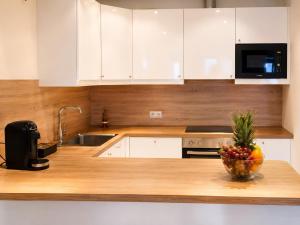 a kitchen with a bowl of fruit on a counter at Luxury Apartment Königsallee Old Town Rhine Promenade Messe in Düsseldorf