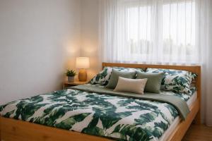 a bedroom with a large bed with green leaves at Apartament Fabryczna Premium TK in Namysłów