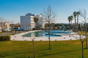 a large pool in a park with a building in the background at Coastal Haven Talea by PikHost in Tale