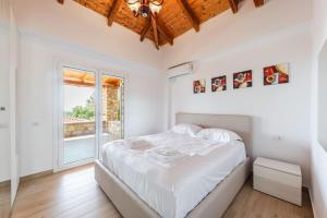 a white bedroom with a bed and a window at Siar The Large Villa by PikHost in Borsh